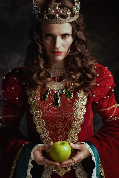 中世纪的女王 穿着红色衣服 绿色苹果 头戴深灰色背景的皇冠 — 图库照片