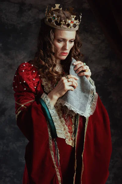 悲哀的中世纪女王 身穿红色衣服 手帕和皇冠 背景是深灰色的 — 图库照片