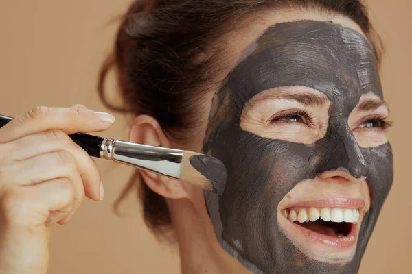 Szczęśliwa Młoda Kobieta Pędzlem Maską Kosmetyczną Odizolowana Beżu — Zdjęcie stockowe