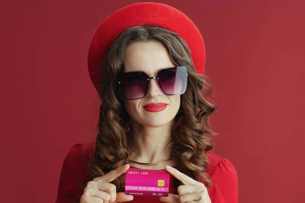 ハッピーバレンタイン 40歳のスタイリッシュな赤のドレスとベレー帽にクレジットカードで隔離された赤 — ストック写真