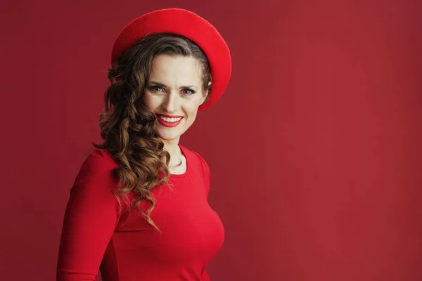 ハッピーバレンタイン 赤のドレスとベレー帽で長い波状の髪を持つ笑顔の現代女性の肖像画赤の背景 — ストック写真