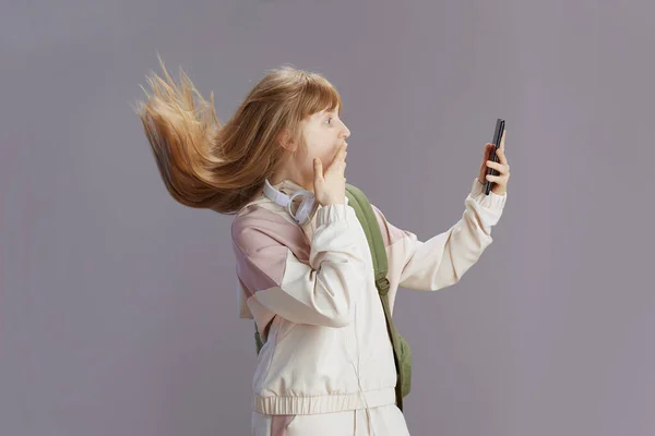 Surpresa Menina Moderna Traje Bege Usando Aplicativos Smartphones Isolados Cinza — Fotografia de Stock