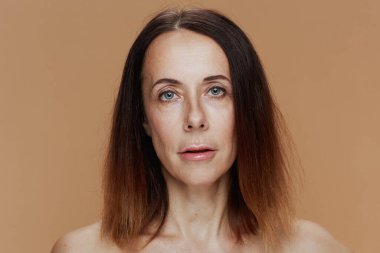 Portrait of modern female with short hair isolated on beige.