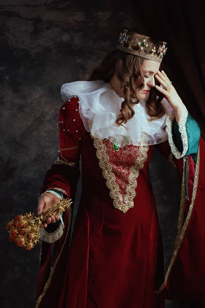 Kurumuş Çiçekli Kırmızı Elbiseli Mutsuz Ortaçağ Kraliçesi Koyu Gri Arka — Stok fotoğraf