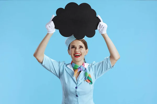 蓝色背景的快乐优雅的女空姐 蓝色制服 显示空白的云彩形状板 — 图库照片