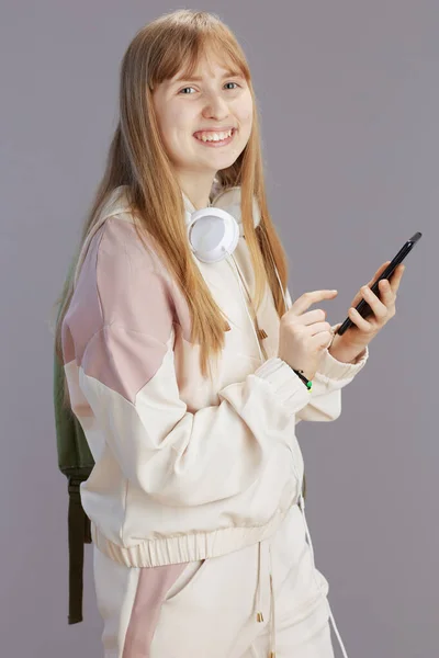 Šťastný Moderní Dospívající Dívka Béžové Teplákové Soupravy Sluchátky Smartphone Izolované — Stock fotografie