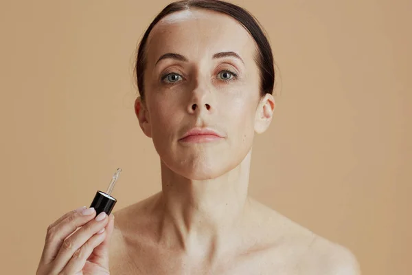 Moderne Jaar Oude Vrouw Met Cosmetische Elixer Tegen Beige Achtergrond — Stockfoto