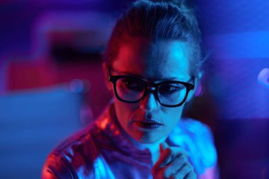 Neon metaevren fütüristik konsepti. Modern ofiste gözlüklü, düşünceli, modern iş kadını.