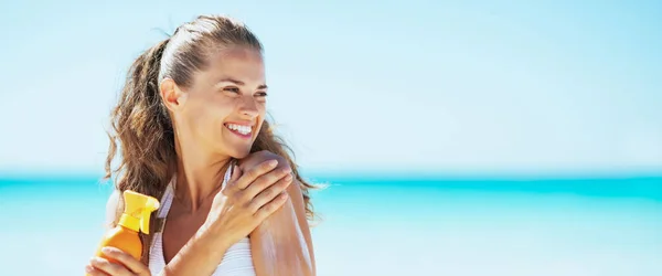 Giovane Donna Sulla Spiaggia Applicando Crema Solare Guardando Sullo Spazio — Foto Stock