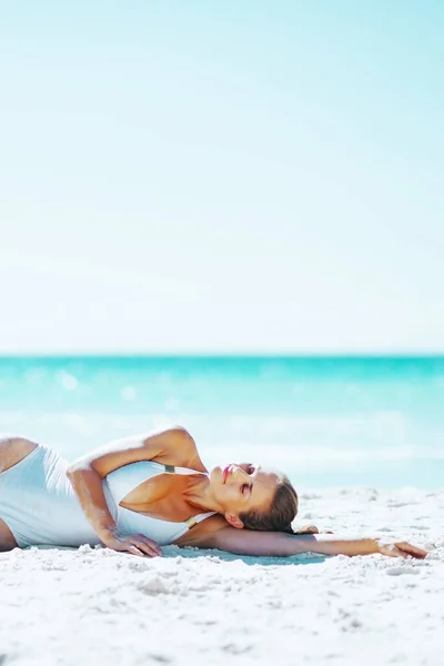 若い女性のビーチの上に敷設 — ストック写真