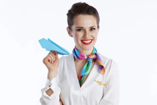 白い背景に青い紙飛行機で隔離されたスタイリッシュなスチュワーデスの女性を笑顔 — ストック写真