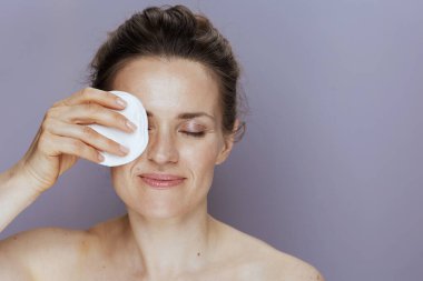 Mavi arka planda pamuk pedi olan rahat modern bir kadın..