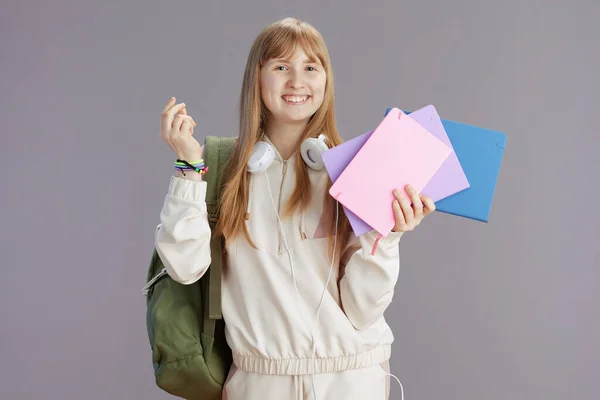 Portret Szczęśliwego Modnego Ucznia Beżowym Dresie Plecakiem Zeszytami Słuchawkami Wyizolowanymi — Zdjęcie stockowe