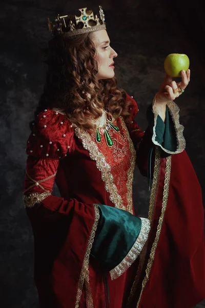 中世纪的女王 穿着红色衣服 绿色苹果 头戴深灰色背景的皇冠 — 图库照片