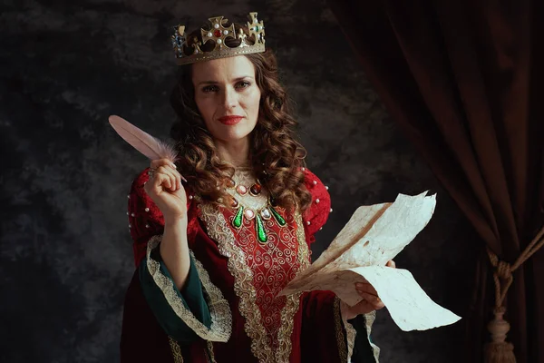 Šťastná Středověká Královna Červených Šatech Pergamenem Korunou Tmavě Šedém Pozadí — Stock fotografie