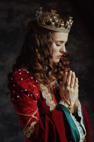 Middeleeuwse Koningin Rode Jurk Met Rozenkrans Kroon Bidden Donkergrijze Achtergrond — Stockfoto