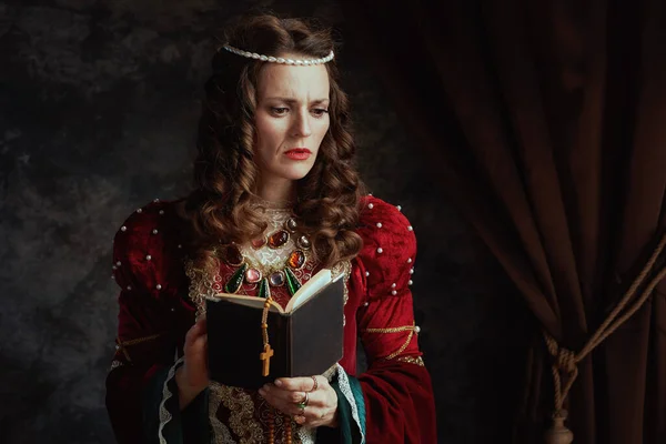 Pensive Middeleeuwse Koningin Rode Jurk Met Boek Rozenkrans Donkergrijze Achtergrond — Stockfoto