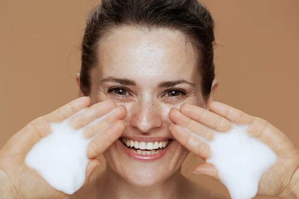 Glad Modern Gammal Kvinna Med Skummande Ansiktsrengöringsmedel Tvätta Ansiktet Beige — Stockfoto