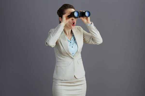 Překvapený Trendy Žena Pracovník Lehkém Obleku Dalekohledem Izolované Šedé Dívá — Stock fotografie