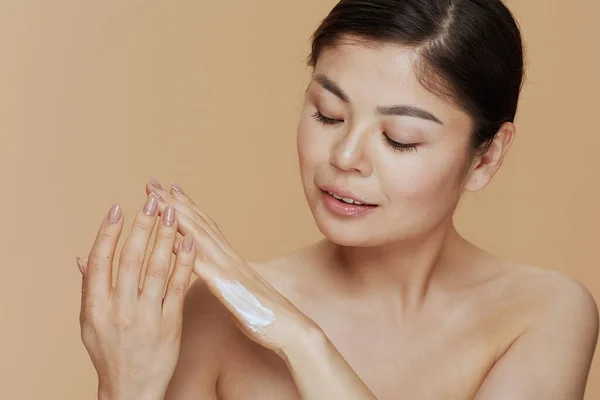 Mujer Asiática Moderna Con Crema Manos Aislada Sobre Fondo Beige — Foto de Stock