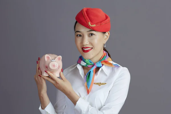 Uśmiechnięta Elegancka Azjatycka Stewardessa Czerwonej Spódnicy Kapeluszu Mundur Świnka Bank — Zdjęcie stockowe