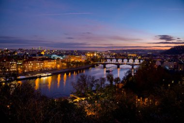 Vltava nehri, Charles Köprüsü ve geceleri Prag, Çek Cumhuriyeti 'nde sonbaharda tekne manzarası.