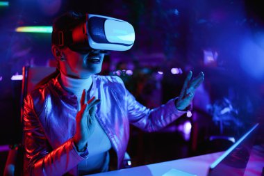 Neon metaevren fütüristik konsepti. Modern ofis modelliğinde sanal gerçeklikte gülümseyen modern iş kadını..