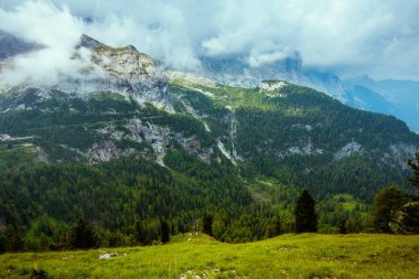 Dolomitlerde yaz zamanı. Dağlı, bulutlu ve ormanlı bir manzara..
