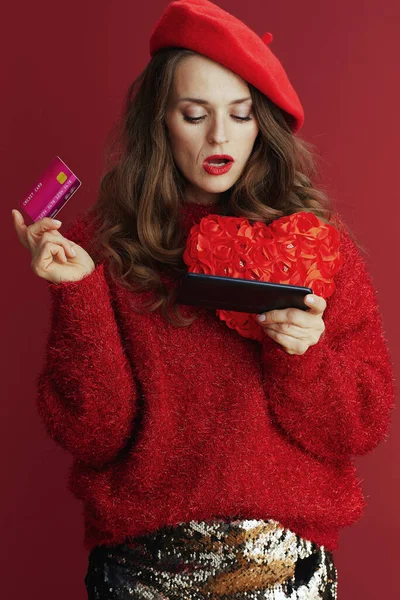 발렌타인 현대의 여성붉은 스웨터와 스마트폰 신용카드로 인터넷을 — 스톡 사진
