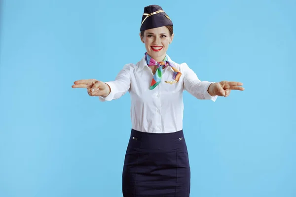 Leende Elegant Kvinnlig Flygvärdinna Mot Blå Bakgrund Uniform Visar Var — Stockfoto