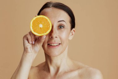 Portakallı, bej arka planda mutlu orta yaşlı kadın portresi..