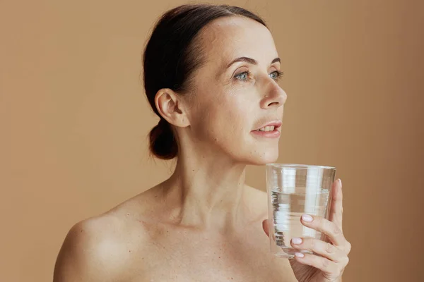 Modern Gammal Kvinna Med Glas Vatten Isolerad Beige — Stockfoto