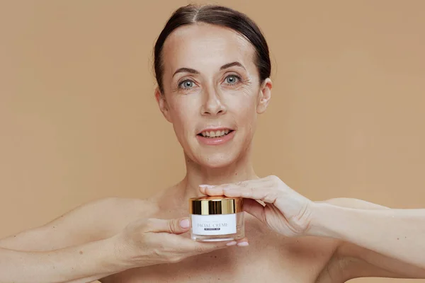 Portret Van Een Glimlachende Moderne Vrouw Met Gezichtscrème Pot Geïsoleerd — Stockfoto