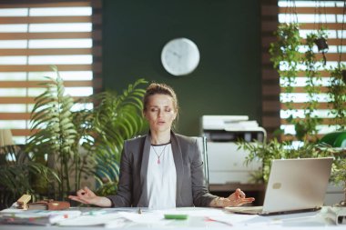Sürdürülebilir iş yeri. Laptop meditasyonu yapan modern iş kadını..