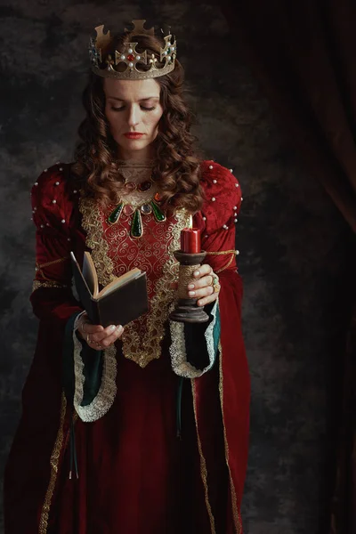 Středověká Královna Červených Šatech Knihou Svíčkou Korunou Tmavě Šedém Pozadí — Stock fotografie