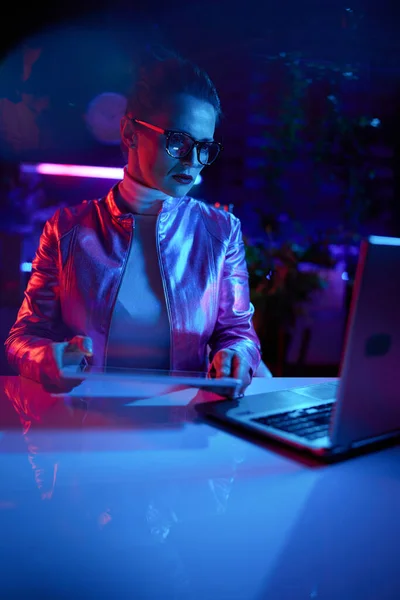 霓虹灯元的未来主义概念 在现代办公室使用平板电脑的眼镜和笔记本电脑的优雅女性 — 图库照片