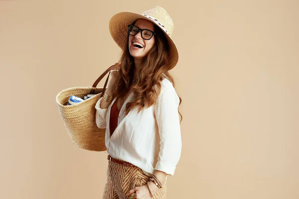 ビーチ休暇 現代の主婦を笑顔で白いブラウスとショートパンツを着たベージュの眼鏡にストローバッグとストローハット — ストック写真