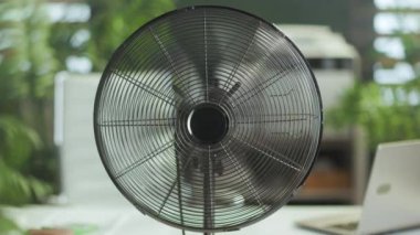 Yaz zamanı. Modern yeşil ofiste metal vantilatör.