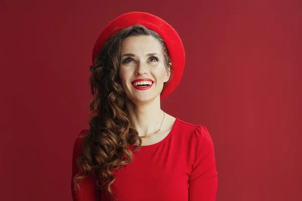 ハッピーバレンタイン 幸せな現代女性で長い波状の髪で赤いドレスとベレー帽は赤の背景に隔離されました — ストック写真