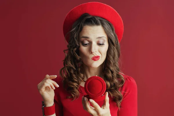 ハッピーバレンタイン 不幸なスタイリッシュな40歳の女性で赤いドレスとベレー帽の赤い背景にジュエリーボックス — ストック写真