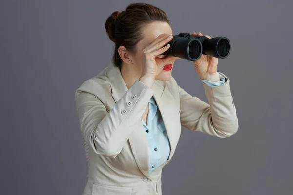 Trendy Vrouwelijke Werknemer Een Licht Zakenpak Met Verrekijker Tegen Grijze — Stockfoto