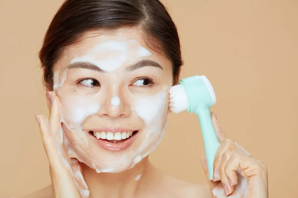 ベージュ地にマッサージ洗顔顔の若い女性 — ストック写真