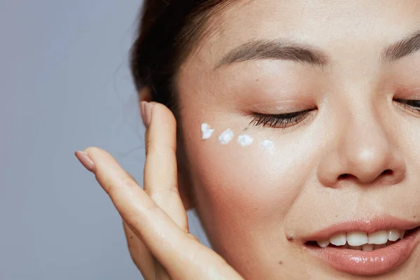 Closeup Modern Asian Female Facial Cream Face Isolated Blue Background — Stock Photo, Image