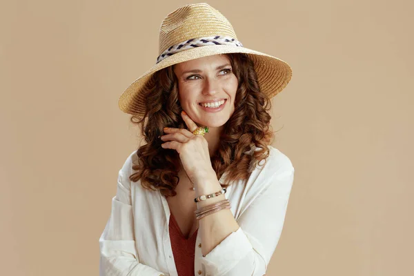 ビーチ休暇 幸せなエレガントな主婦で白いブラウスとショートパンツ隔離上のベージュの背景とともに夏の帽子 — ストック写真