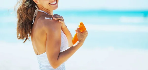 Sorridente Giovane Donna Sulla Spiaggia Applicando Crema Solare — Foto Stock