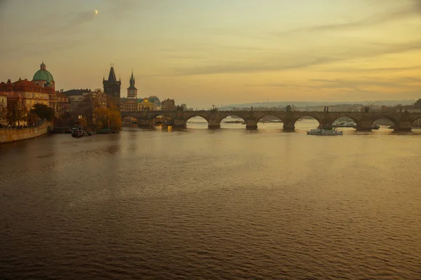 チェコ共和国プラハの秋の日没時にヴルタヴァ川とカレル橋と風景 — ストック写真