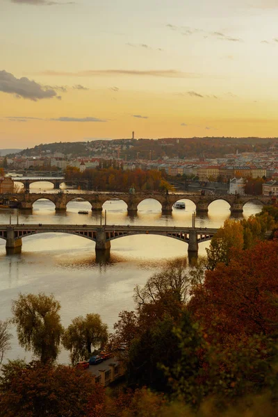 チェコ共和国プラハの秋の紅葉で撮影された日没時のヴルタヴァ川とカレル橋の風景 — ストック写真