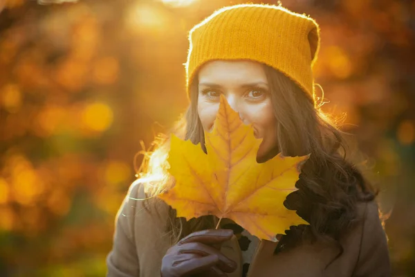 今年秋天 穿着米黄色外套 头戴橙色帽子的40岁的老太婆躲在秋天的黄色衣服后面 走在城市公园的室外 — 图库照片