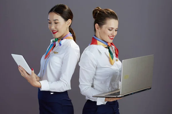 Uśmiechnięta Stylowa Stewardessa Niebieskiej Spódnicy Białej Koszuli Szaliku Laptopem Tabletem — Zdjęcie stockowe