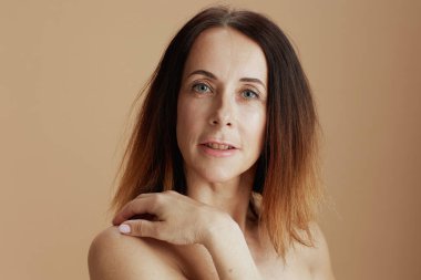 Portrait of modern middle aged woman with short hair isolated on beige.